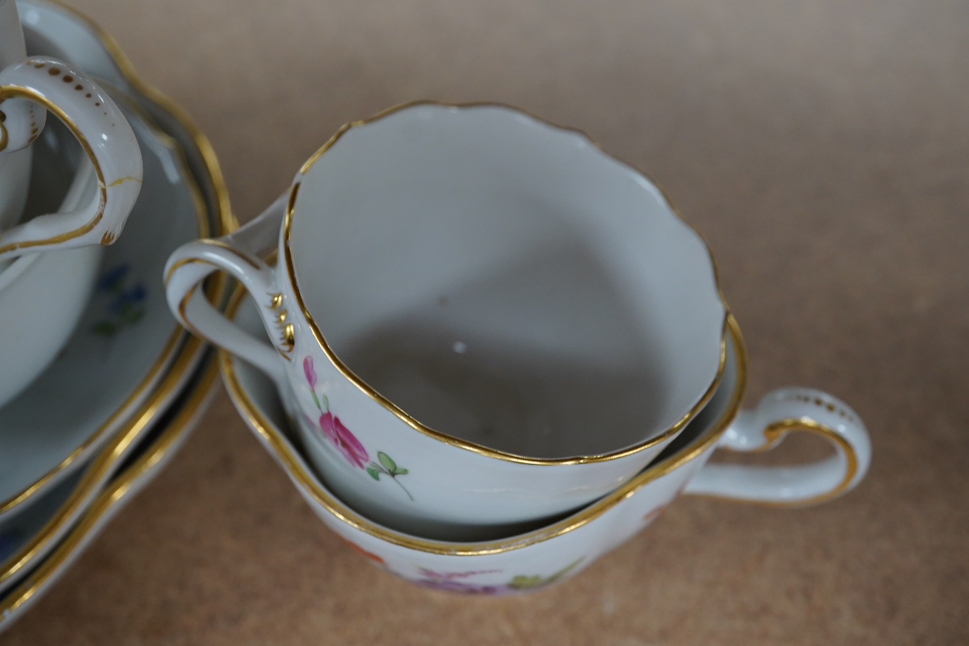 A group of 19th century Meissen porcelain cups and saucers. Condition - one teacup has a re-glued handle